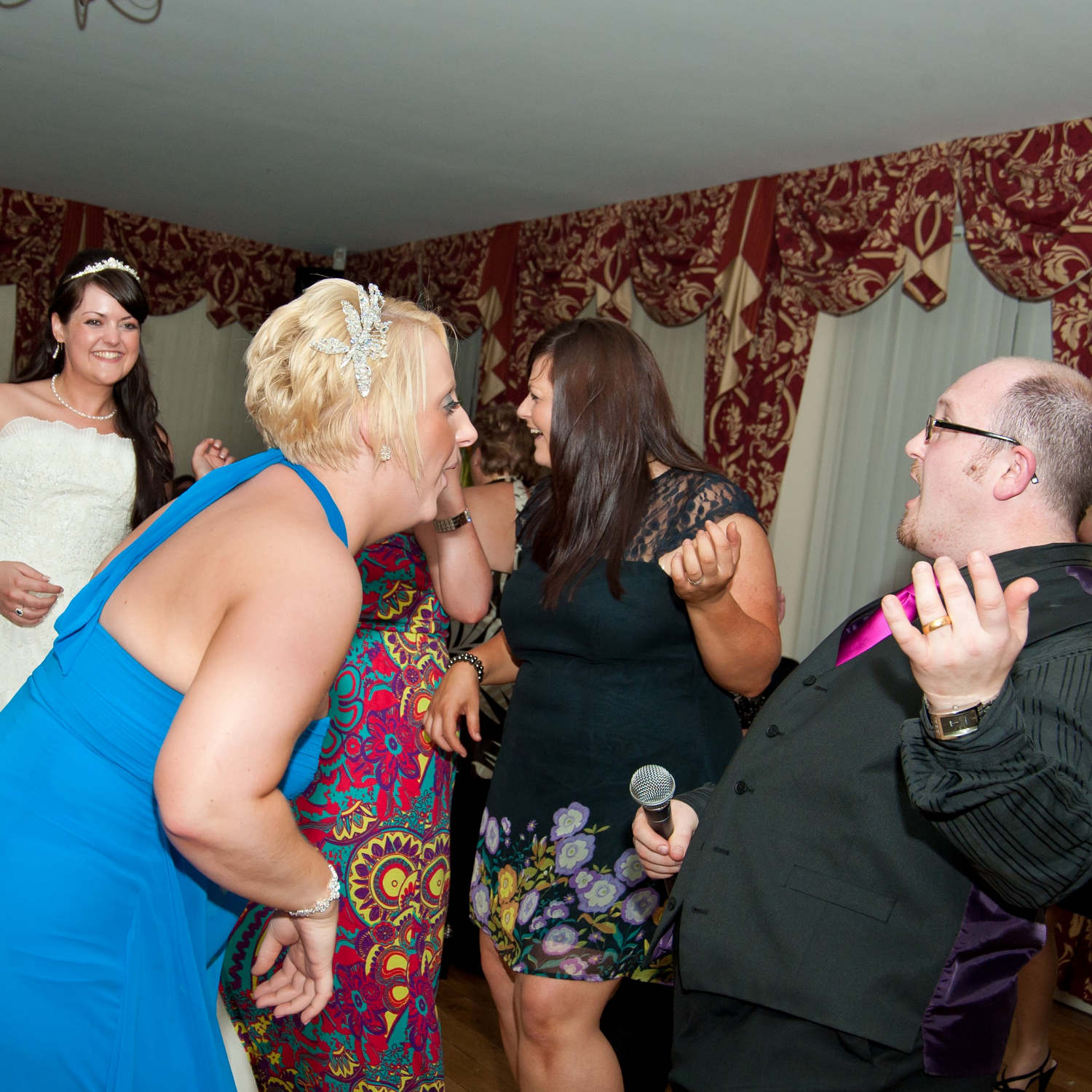 Jon Paul singing waiter and bride with guests sing along and play air guitar at wedding reception in wales.